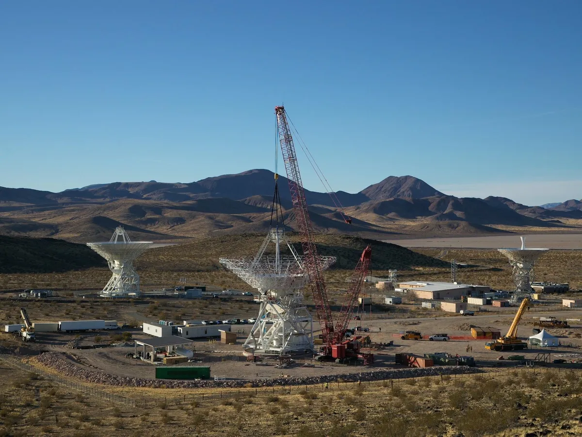 Кран сваля носеща конструкция върху рефлектора на антената DSS-23 в Goldstone